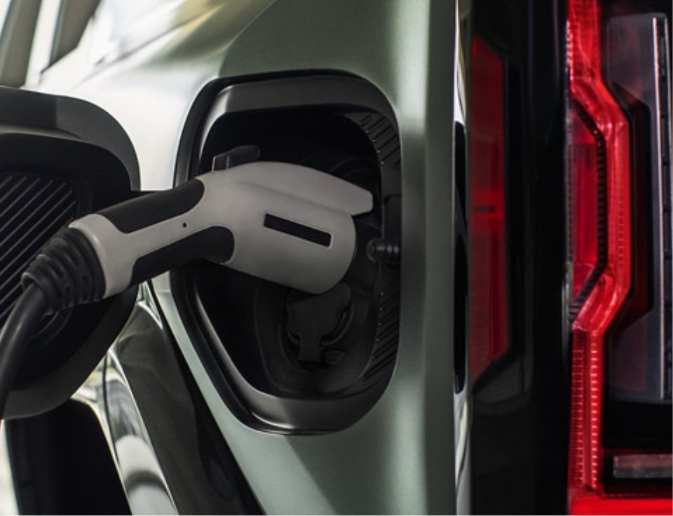 Close up of charging port with charger plugged in on a GMC Hummer EV SUV - Raymond Motor Company in CENTER TX